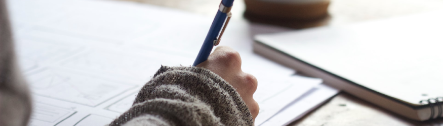 Person writing something on a piece of paper. [1]