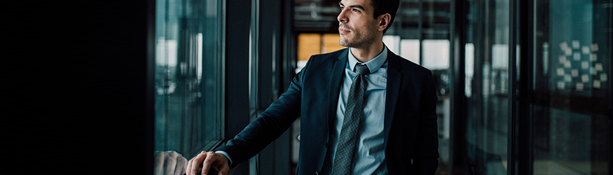 A man wearing a suit is standing in an aisle.