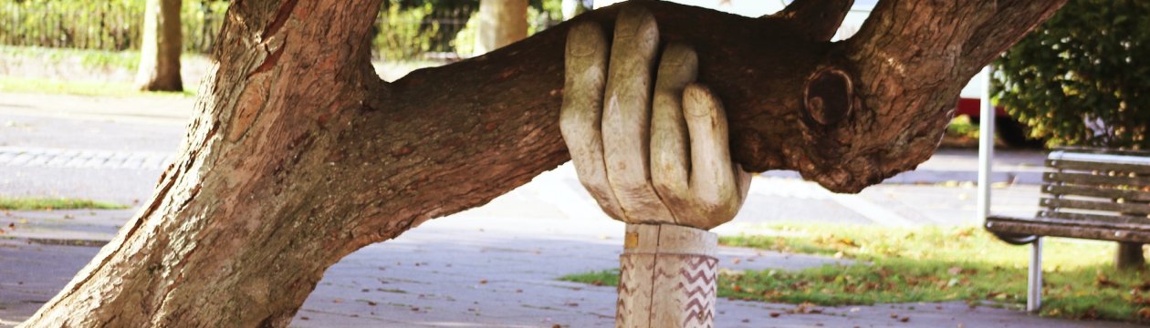 Eine Statue einer Hand, die einen Baum hält.