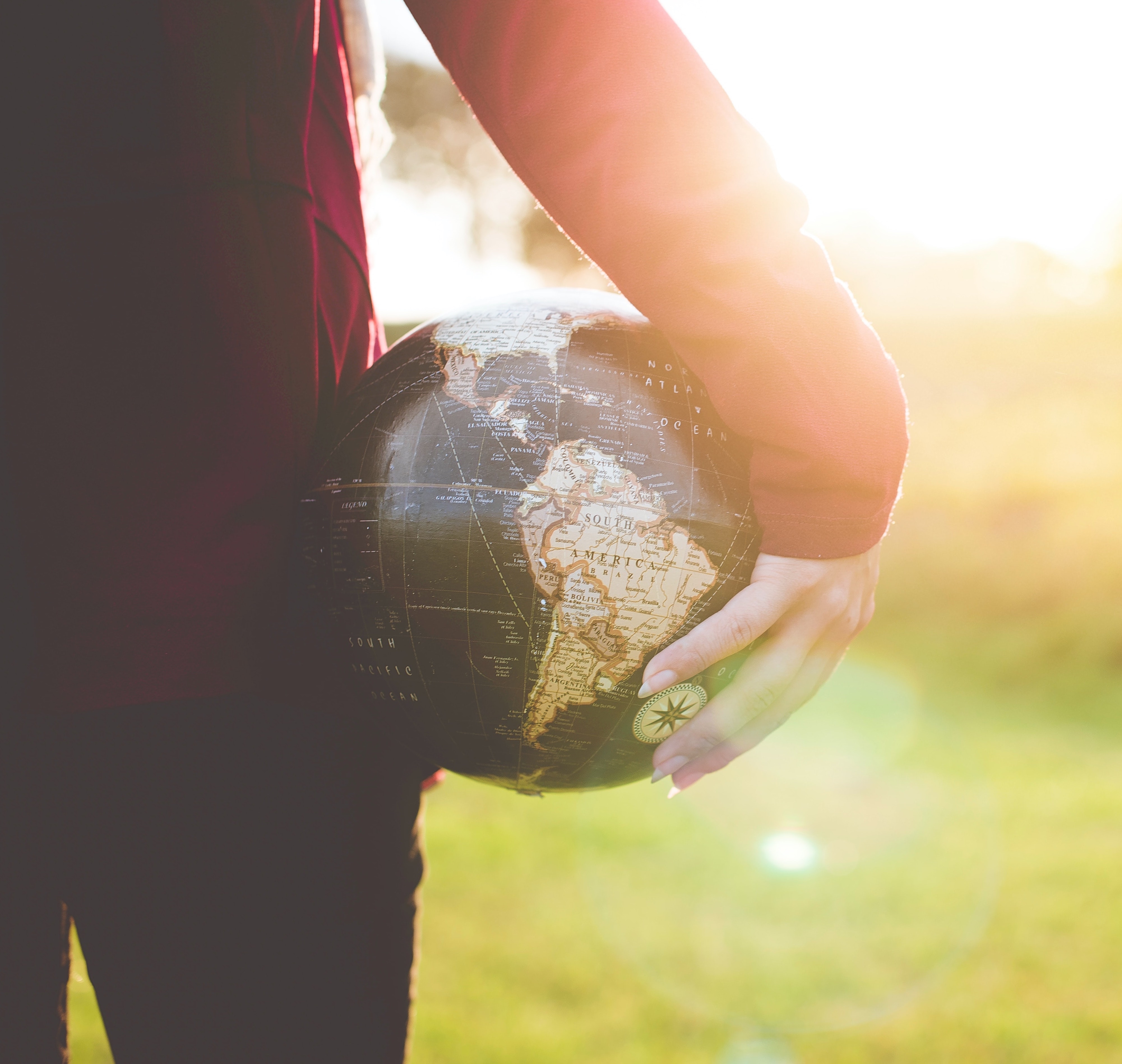 A person is holding a globe.