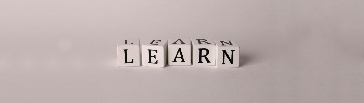 Five white cubes with black letters spell the word "LEARN" on a gray background. Five white cubes with black letters spell the word "LEARN" on a gray background.
