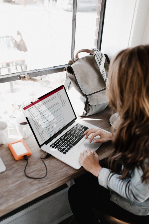 A brown-haired woman works on her laptop.