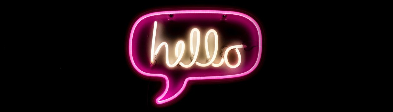A neon sign in the form of a speech bubble with the word "hello" written on it.