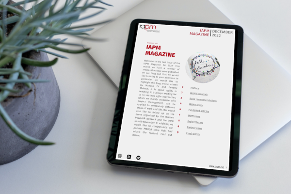 Tablet liegt neben einer Pflanze auf einem Tisch und zeigt das Cover des IAPM Magazine December. Tablet liegt neben einer Pflanze auf einem Tisch und zeigt das Cover des IAPM Magazine December.