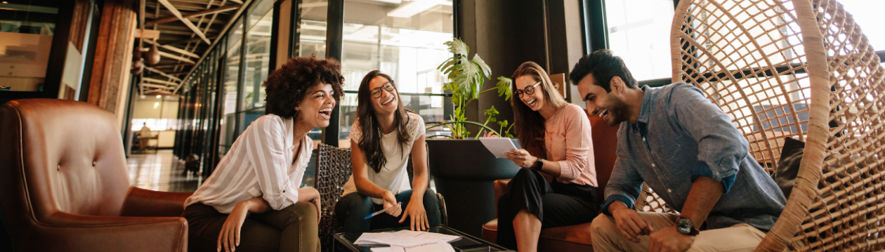 Four colleagues laugh in a modern office. Four colleagues laugh in a modern office.