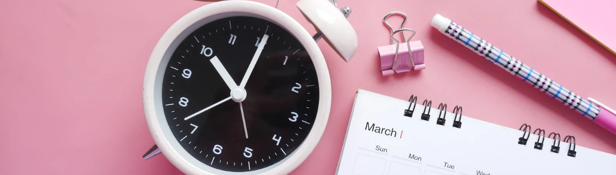 Uhr und Kalender auf einem Schreibtisch als Symbol für Terminplanung und zeitliche Puffer