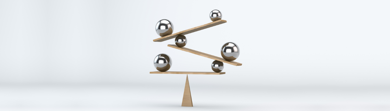 Wooden balance with six spheres on inclined planes against a white background.