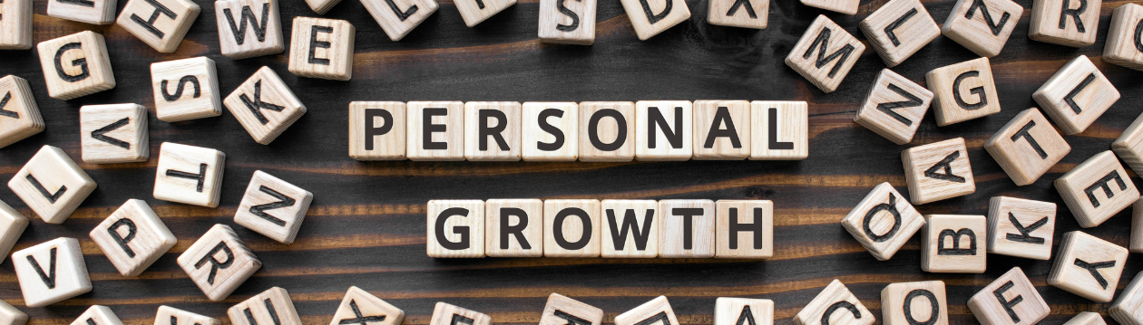 Wooden letter blocks spell out “PERSONAL GROWTH” on a dark wood background with scattered letters. Wooden letter blocks spell out “PERSONAL GROWTH” on a dark wood background with scattered letters.