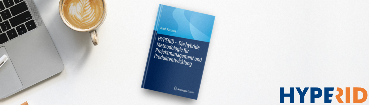 The HYPERID book lies on a desk. Next to it are a laptop and a coffee.