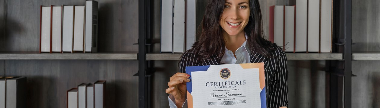 A young woman proudly holds a certificate in the camera.