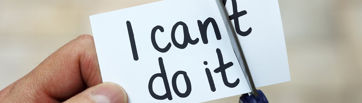 Auf einem Zettel steht "I can't do it", was von einer Schere zu "I can do it" beschnitten wird