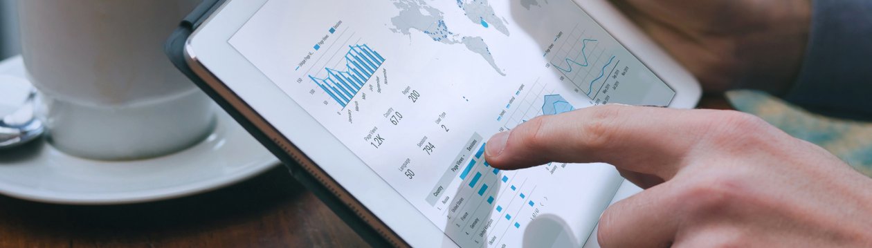 Person tippt auf ein Tablet mit unterschiedlichen Diagrammen darauf. Person tippt auf ein Tablet mit unterschiedlichen Diagrammen darauf.