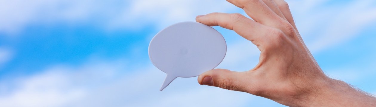 A person holds a speech bubble in his hand.