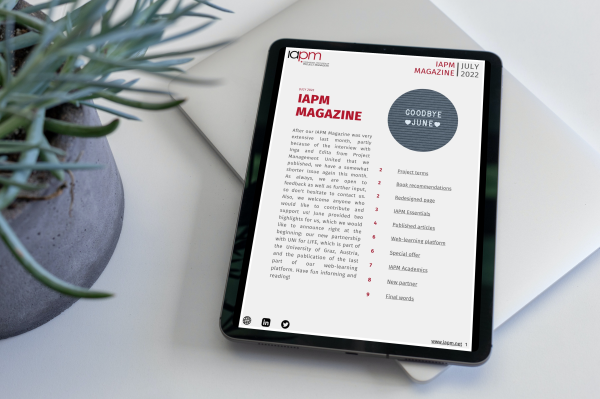 Tablet liegt neben einer Pflanze auf einem Tisch und zeigt das Cover des IAPM Magazine July Tablet liegt neben einer Pflanze auf einem Tisch und zeigt das Cover des IAPM Magazine July