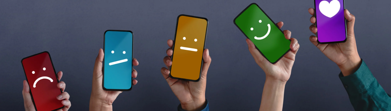 Several hands hold up mobile phones with different smileys in different colours. Several hands hold up mobile phones with different smileys in different colours.