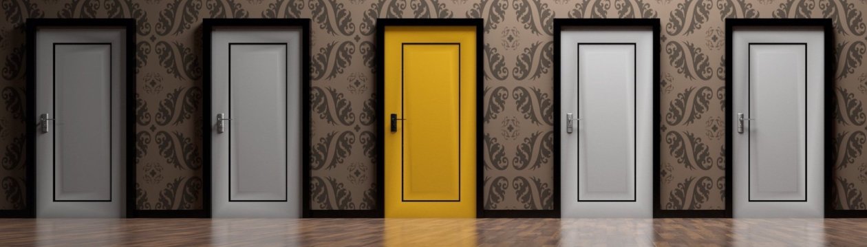 Fünf Türen, die Tür in der Mitte ist gelb, alle anderen sind weiß.