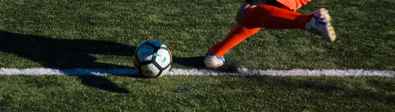 Ein Fußballspieler, der einen Ball schießt. Ein Fußballspieler, der einen Ball schießt.