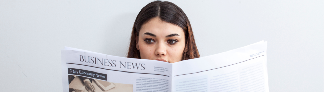 A woman reading a newspaper. A woman reading a newspaper.