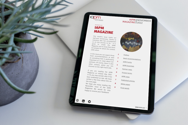 Tablet liegt neben einer Pflanze auf einem Tisch und zeigt das Cover des IAPM Magazine November. Tablet liegt neben einer Pflanze auf einem Tisch und zeigt das Cover des IAPM Magazine November.