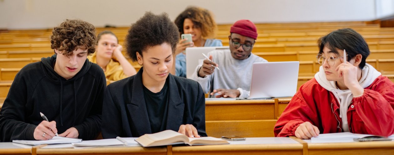 Several young people sitting in a lecture hall. 