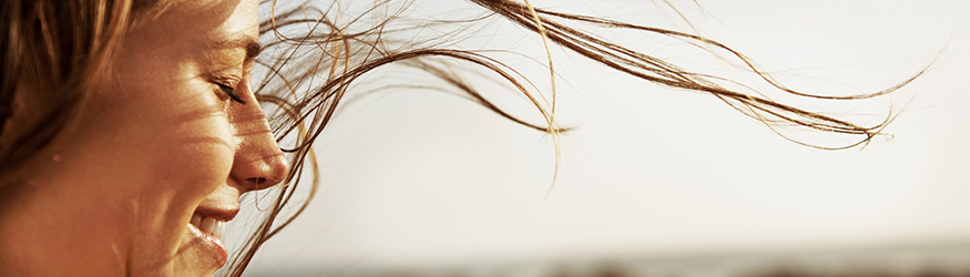 Blonde woman with hair blowing in the wind. 