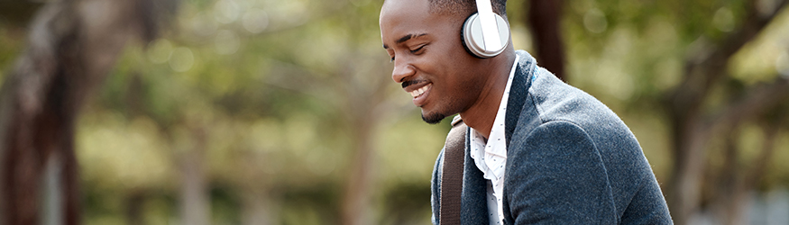 Man in blue jacket wears white headphones.