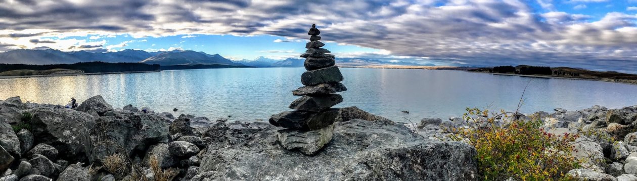 A stone stack on a rock by the water.