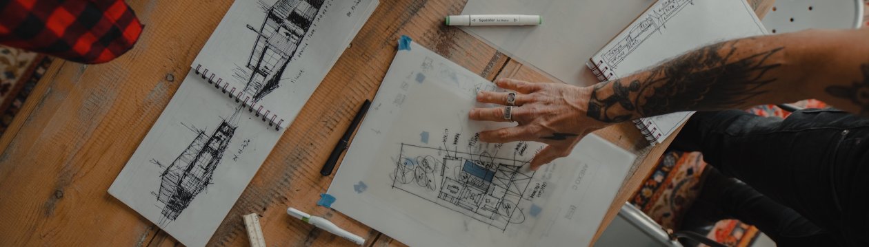 A hand placed on design drawings. A hand placed on design drawings.