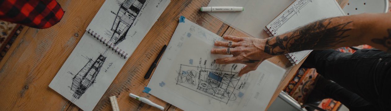 A hand placed on design drawings.