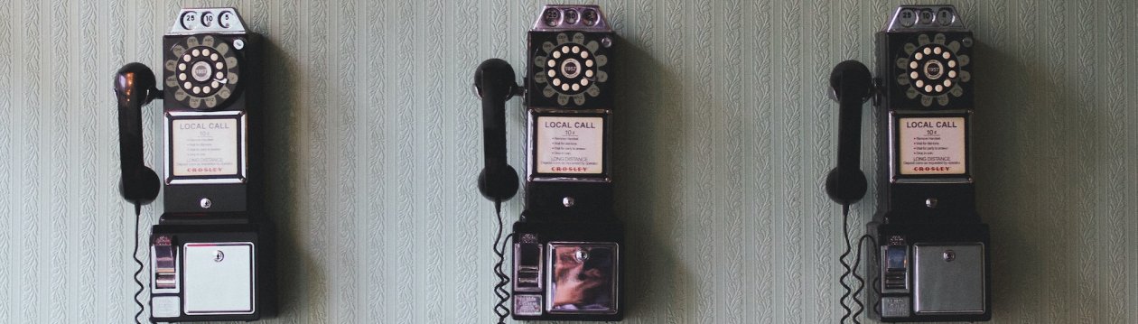 Three black pay phones on one wall. Three black pay phones on one wall.
