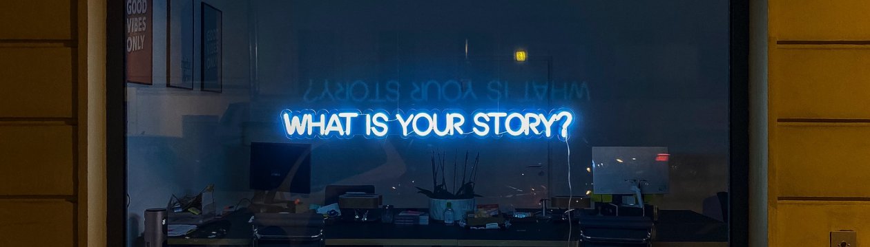 A neon sign "WHAT IS YOUR STORY?" A neon sign "WHAT IS YOUR STORY?"