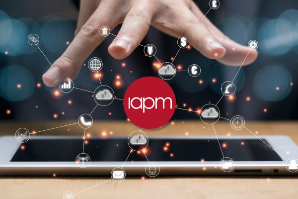 A person holds their open hand over the IAPM logo and digital symbols.