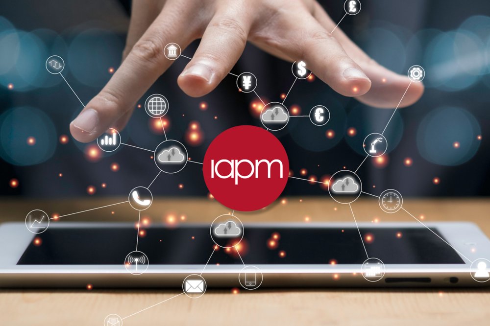 Eine Person hält ihre offene Hand über das Logo der IAPM sowie digitale Symbole.