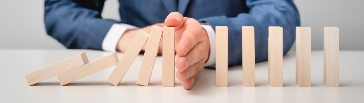 A hand stops falling wooden blocks in a row. A hand stops falling wooden blocks in a row.