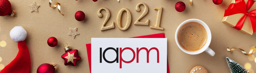 Schriftzug IAPM mit einer darüber stehenden 2021 und Weihnachtsdekoration.