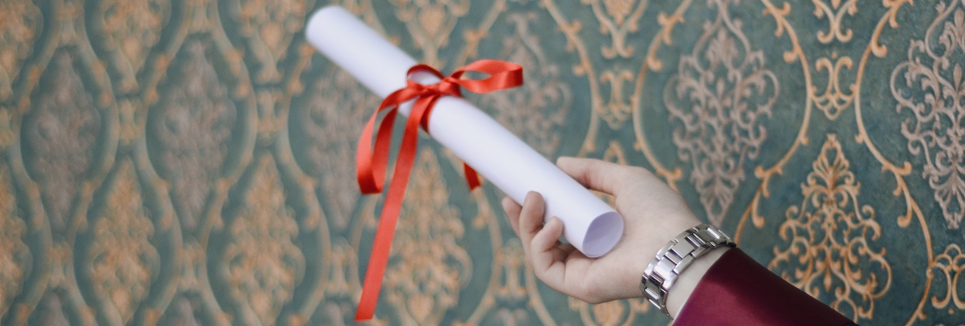 A person holds a certificate in the air.